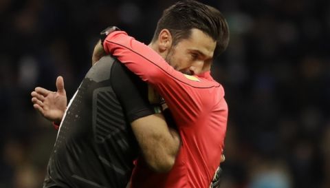Referee Antonio Mateu Lahoz of Spain hugs Italy goalkeeper Gianluigi Buffon at the end of the first half during the World Cup qualifying play-off second leg soccer match between Italy and Sweden, at the Milan San Siro stadium, Italy, Monday, Nov. 13, 2017. (AP Photo/Luca Bruno)
