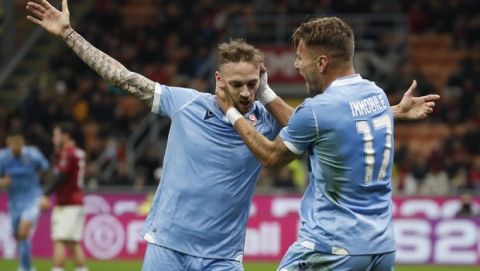 Lazio's Ciro Immobile, right, and Manuel Lazzari celebrate after scoring the opening goal during the Serie A soccer match between AC Milan and Lazio at the San Siro stadium, in Milan, Italy, Sunday, Nov. 3, 2019, (AP Photo/Antonio Calanni)
