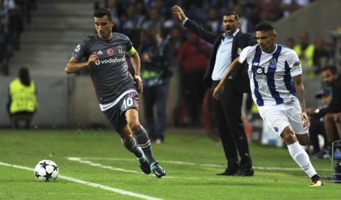 Besiktas' Oguzhan Ozyakup runs with the ball as Porto coach Sergio Conceicao gestures in the background during the Champions League group G soccer match between FC Porto and Besiktas at the Dragao stadium in Porto, Portugal, Wednesday, Sept. 13, 2017. (AP Photo/Paulo Duarte)