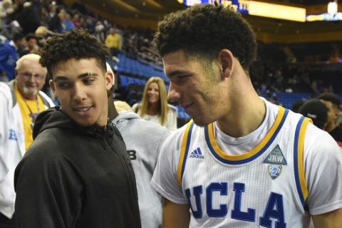 FILE - In this Nov. 20, 2016, file photo, UCLA's Lonzo Ball (2) greets his brother LiAngelo Ball, left, and father LaVar Ball, right, after scoring 20 points in their 114-77 win over Long Beach State at an NCAA college basketball game in Los Angeles. The UCLA Bruins open preparations for a new season with another Ball brother in the lineup. With Lonzo Ball off to the Lakers after one season, his middle brother LiAngelo takes up residence in Westwood. (AP Photo/Michael Owen Baker, File)