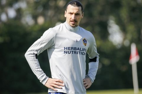 LA Galaxy's newest player Zlatan Ibrahimovic, center, of Sweden, looks on as he warms up during an MLS soccer training session at the StubHub Center, Friday, March 30, 2018, in Carson, Calif. (AP Photo/Ringo H.W. Chiu)