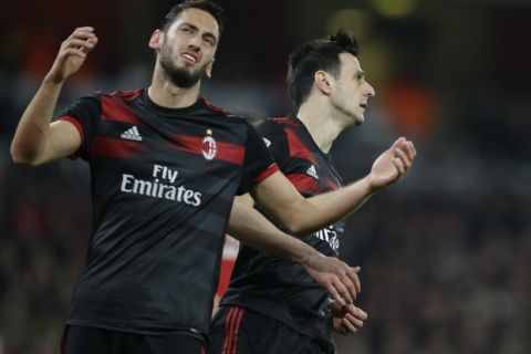 AC Milan's Hakan Calhanoglu, left is flanked by his teammate Nikola Kalinicduring the Europa League round of 16 second leg soccer match between Arsenal and AC Milan at the Emirates stadium in London, Thursday, March, 15, 2018. (AP Photo/Alastair Grant)