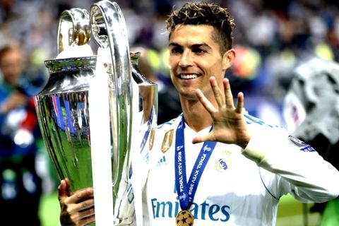 FILE - In this Saturday, May 26, 2018 file photo Real Madrid's Cristiano Ronaldo celebrates with the trophy after winning the Champions League Final soccer match between Real Madrid and Liverpool at the Olimpiyskiy Stadium in Kiev, Ukraine. Cristiano Ronaldo says it was his "destiny" to join Juventus as he tries to become only the second player to win the Champions League with three different clubs. Ronaldo moved from Real Madrid to Juventus in a Serie A record 112 million euro (then $131.5 million) deal. (AP Photo/Pavel Golovkin)
