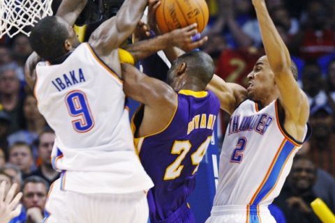 Oklahoma City Thunder center Serge Ibaka of Congo fouls Los Angeles Lakers guard Kobe Bryant (C) as Thunder guard Thabo Sefolosha (R) of Switzerland defends in the second half of their NBA basketball game in Oklahoma City February 27, 2011.  REUTERS/Bill Waugh (UNITED STATES - Tags: SPORT BASKETBALL)