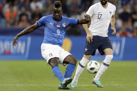 Italy's Mario Balotelli, left, kicks the ball while France's Edil Rami looks on during a friendly soccer match between France and Italy at the Allianz Riviera stadium in Nice, southern France, Friday, June 1, 2018. (AP Photo/Claude Paris)