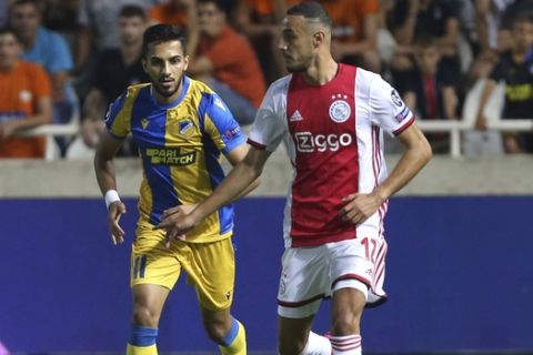 Ajax's Noussair Mazraoui, right, challenges for the ball with APOEL's Musa Suleiman during the Champions League qualifying playoff first leg soccer match at GSP stadium in Nicosia, Cyprus, Tuesday, Aug. 20, 2019. (AP Photo/Philippos Christou)