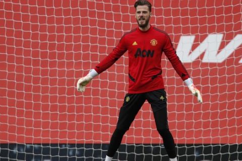 Manchester United's goalkeeper David de Gea warms up ahead of the English Premier League soccer match between Manchester United and West Ham at the Old Trafford stadium in Manchester, England, Wednesday, July 23, 2020. (Clive Brunskill/Pool via AP)