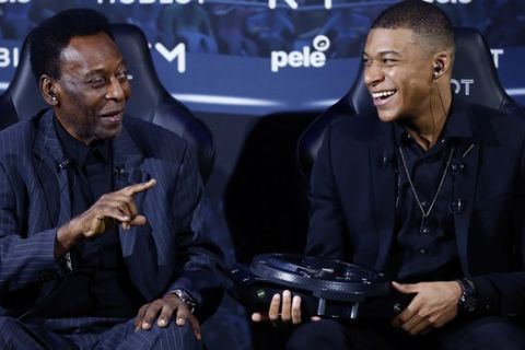 Brazilian soccer legend Pele, left, and French soccer player Kylian Mbappe joke during a photocall in Paris, Tuesday, April 2, 2019. (AP Photo)