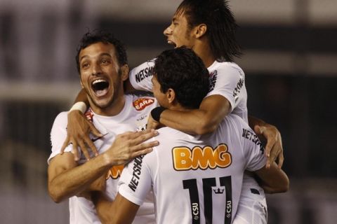 Neymar (C), Edu Dracena (L) and Ganso of Brazil's Santos celebrate beating Argentina's Velez Sarsfield in a penalty shootout during their quarter-final Copa Libertadores soccer match in Santos May 24, 2012.       REUTERS/Paulo Whitaker (BRAZIL - Tags: SPORT SOCCER)