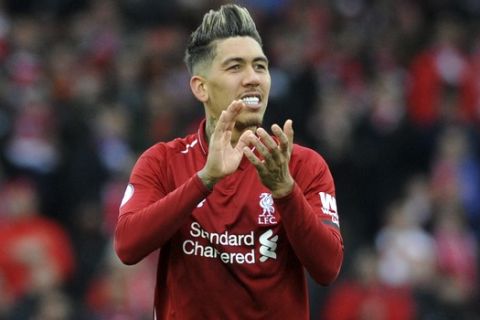 Liverpool's Roberto Firmino applauds to supporters at the end of the English Premier League soccer match between Liverpool and Chelsea at Anfield stadium in Liverpool, England, Sunday, April 14, 2019. (AP Photo/Rui Vieira)
