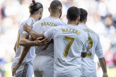 Real Madrid's Karim Benzema, second left, is congratulated by teammates after scoring during the Spanish La Liga soccer match between Real Madrid and Granada at the Santiago Bernarbeu stadium in Madrid, Saturday, Oct. 5, 2019. (AP Photo/Bernat Armangue)