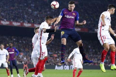 FC Barcelona's Clement Lenglet, center, heads for the ball during the Spanish La Liga soccer match between FC Barcelona and Sevilla at the Camp Nou stadium in Barcelona, Spain, Saturday, Oct. 20, 2018. (AP Photo/Manu Fernandez)