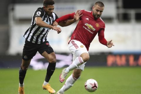 Newcastle's Joelinton, left, duels for the ball with Manchester United's Luke Shaw during the English Premier League soccer match between Newcastle United and Manchester United at St. James' Park in Newcastle, England, Saturday, Oct. 17, 2020. (Alex Pantling/Pool via AP)