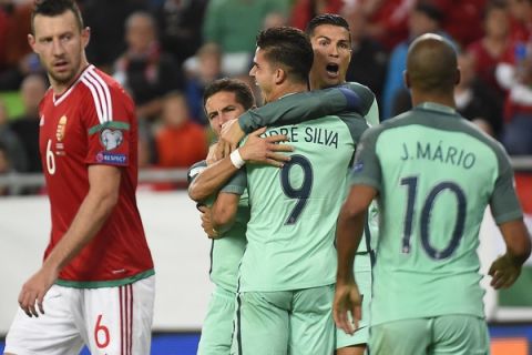Hungary's Elek Akos, left looks as Portugal's Cristiano Ronaldo, background, centre right, celebrates his teammate Andre Silva's goal, during the World Cup Group B first round soccer match between Hungary and Portugal, at the Groupama Arena, in Budapest, Hungary, Sunday, Sept. 3, 2017. (Tamas Kovacs//MTI via AP)