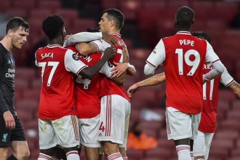 Arsenal players celebrate after scoring their second goal during the English Premier League soccer match between Arsenal and Liverpool at the Emirates Stadium in London, England, Wednesday, July 15, 2020. Glyn Kirk/Pool via AP)