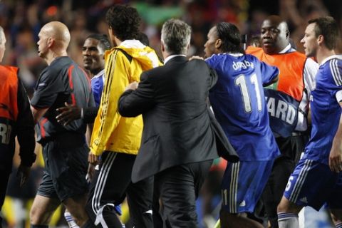 Chelsea players John Terry, right, Didier Drogba, second right, coach Guus Hiddink and player Florent Malouda, third left, crowd around referee Tom Ovrebo, second left, as they leave the pitch following their Champions League semifinal second leg soccer match against Barcelona at Chelsea's Stamford Bridge stadium in London, Wednesday, May 6, 2009. Chelsea says it will take strong action against any fans found to have made threats against the Norwegian referee who officiated the club's Champions League semifinal against Barcelona.  London's Evening Standard newspaper said Thursday that death threats have been made over the Internet against referee Tom Henning Ovrebo.  (AP Photo/Jon Super)