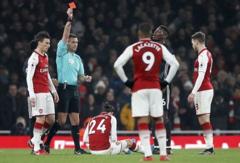 Referee Andre Marriner shows a red card to Manchester United's Paul Pogba, 2nd right, during the English Premier League soccer match between Arsenal and Manchester United at the Emirates stadium in London, Saturday, Dec. 2, 2017. (AP Photo/Kirsty Wigglesworth)