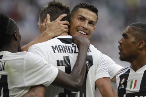 Juventus' Mario Mandzukic, is hugged by teammate Juventus' Cristiano Ronaldo, after scoring his sides second goal of the game during the Serie A soccer match between Juventus and Lazio at the Allianz Stadium in Turin, Italy, Saturday, Aug. 25, 2018. (AP Photo/Luca Bruno)