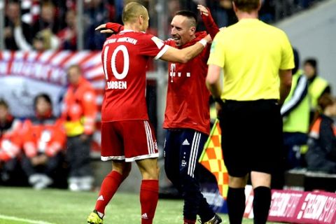 Munich's Arjen Robben, left, celebrates his second goal with Franck Ribery who sits on the bench during the first division Bundesliga soccer match between Bayern Munich and FSV Mainz 05 in Munich, Germany, Saturday, Sept. 16, 2017. (Andreas Gebert/dpa via AP)