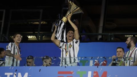Juventus' Cristiano Ronaldo holds up the trophy as Juventus players celebrate winning an unprecedented ninth consecutive Italian Serie A soccer title, at the end of the a Serie A soccer match between Juventus and Roma, at the Allianz stadium in Turin, Italy, Saturday, Aug.1, 2020. (AP Photo/Luca Bruno)