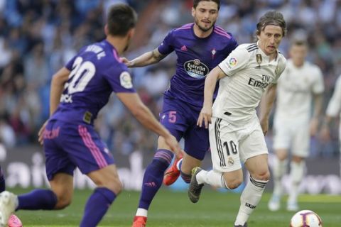 Real Madrid's Luka Modric, right, challenges for the ball with Celta's Kevin Vazquez during a Spanish La Liga soccer match between Real Madrid and Celta at the Santiago Bernabeu stadium in Madrid, Spain, Saturday, March 16, 2019. (AP Photo/Paul White)
