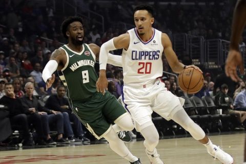 Los Angeles Clippers' Landry Shamet (20) dribbles next to Milwaukee Bucks' Wesley Matthews (9) during the first half of an NBA basketball game Wednesday, Nov. 6, 2019, in Los Angeles. (AP Photo/Marcio Jose Sanchez)