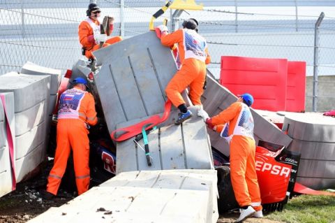 SOCHI, RUSSIA - OCTOBER 10:  Course marshalls remove barriers from the top of Carlos Sainz of Spain and Scuderia Toro Rosso's damaged car after he crashed during final practice for the Formula One Grand Prix of Russia at Sochi Autodrom on October 10, 2015 in Sochi, Russia.  (Photo by Lars Baron/Getty Images)