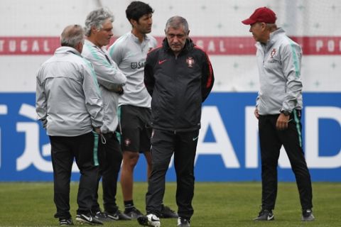 Portugal head coach Fernando Santos, front, walks along the pitch during the training session of Portugal at the 2018 soccer World Cup in Kratovo, outskirts Moscow, Russia, Wednesday, June 13, 2018. (AP Photo/Francisco Seco)