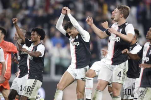 Juventus' Cristiano Ronaldo, center, and his teammates celebrate at the end of a Serie A soccer match between Juventus and Bologna, at the Allianz stadium in Turin, Italy, Saturday, Oct.19, 2019. Juventus won 2-1. (AP Photo/Luca Bruno)