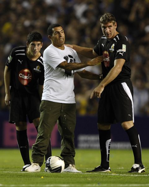 Argentine footballer Carlos Tevez (C) next to footballer Martin Palermo (R) and his son Ryduan (L), prepares to give the starting kick for Palermo's farewell football match, at La Bombonera stadium in Buenos Aires, on February 4, 2012. AFP PHOTO / Alejandro PAGNI (Photo credit should read ALEJANDRO PAGNI/AFP/Getty Images)
