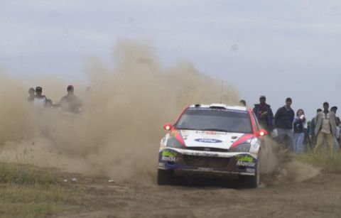 Colin Mcrae, with Co-driver Nicky Crist, both from Great Britain, leaves a cloud of dust, in their Ford Focus RS WRC 02, Car No 5, during the final third leg of the Worlds greatest rally, the Safari Rally 2002, near Ntulele, Kenya  Sunday, July 14, 2002.  Mcrae was lying first on points  at the start of the third leg. (AP Photo/Khalil Senosi)