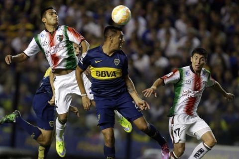 Andres Chavez of Argentina's Boca Juniors, center, jumps for the ball flanked by Esteban Carvajal, right, and Paulo Diaz, left, of Chile's Palestino during a Copa Libertadores soccer match in Buenos Aires, Argentina, Thursday, April 16, 2015. (AP Photo/Victor R. Caivano)