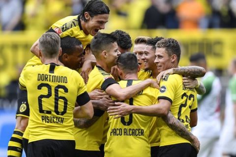 Dortmund's Paco Alcacer is celebrated after he scored his second goal during the German Bundesliga soccer match between Borussia Dortmund and FC Augsburg at the Signal Iduna Park stadium in Dortmund, Germany, Saturday, Aug. 17, 2019. Dortmund defeated Augsburg with 5-1. (AP Photo/Martin Meissner)