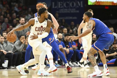 Cleveland Cavaliers guard Donovan Mitchell (45) passes against New York Knicks forwards Cam Reddish (0) and Obi Toppin (1) during the second half of an NBA basketball game, Sunday, Oct. 30, 2022, in Cleveland. (AP Photo/Nick Cammett)