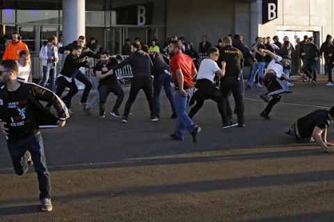 Supporters fight outside the stadium before the Europa League quarterfinal soccer match between Lyon and Besiktas, in Decines, near Lyon, central France, Thursday, April 13, 2017. (AP Photo/Laurent Cipriani)