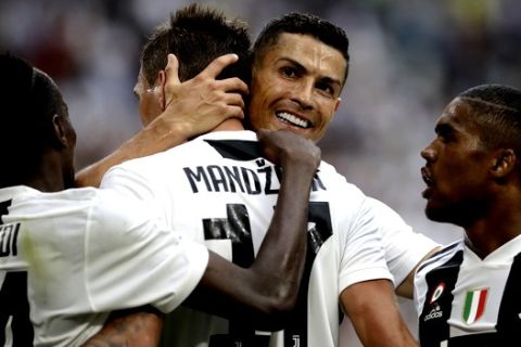 Juventus' Mario Mandzukic, is hugged by teammate Juventus' Cristiano Ronaldo, after scoring his sides second goal of the game during the Serie A soccer match between Juventus and Lazio at the Allianz Stadium in Turin, Italy, Saturday, Aug. 25, 2018. (AP Photo/Luca Bruno)