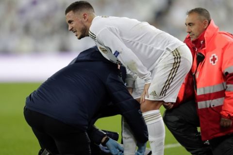 Real Madrid's Eden Hazard reacts after been injured during a Champions League soccer match Group A between Real Madrid and Paris Saint Germain at the Santiago Bernabeu stadium in Madrid, Spain, Tuesday, Nov. 26, 2019. (AP Photo/Bernat Armangue)