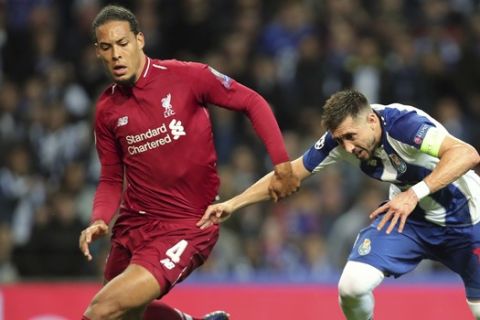 Liverpool's Virgil van Dijk, left, duels for the ball with Porto midfielder Hector Herrera during the Champions League quarterfinals, 2nd leg, soccer match between FC Porto and Liverpool at the Dragao stadium in Porto, Portugal, Wednesday, April 17, 2019. (AP Photo/Luis Vieira)