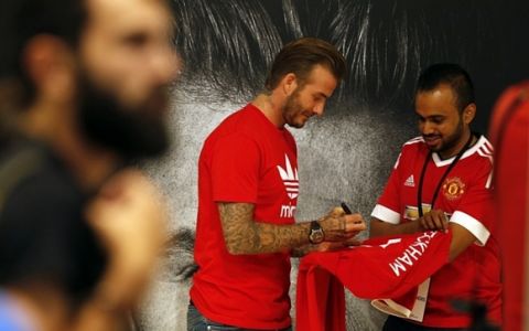 Footballing legend David Beckham signs a jersey for a fan following his arrival in Dubai's Mall of the Emirates on September 29, 2015, during a trip to the Gulf emirate. AFP PHOTO/KARIM SAHIBKARIM SAHIB/AFP/Getty Images