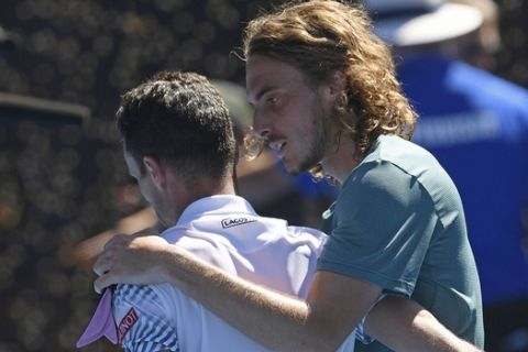 Greece's Stefanos Tsitsipas, right, talks with Spain's Roberto Bautista Agut after winning their quarterfinal match at the Australian Open tennis championships in Melbourne, Australia, Tuesday, Jan. 22, 2019. (AP Photo/Andy Brownbill)