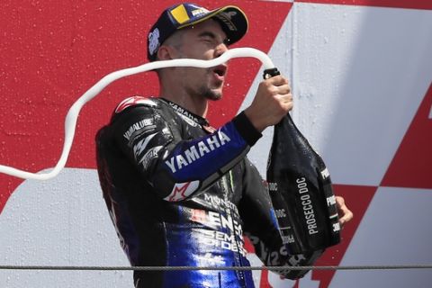 Spain's rider Maverick Vinales of the Monster Energy Yamaha MotoGP sprays champagne to celebrate his victory in the MotoGP race during the Dutch Grand Prix in Assen, northern Netherlands, Sunday, June 30, 2019. (AP Photo/Peter Dejong)