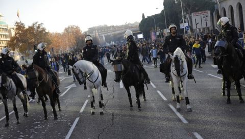 Mounted police officers look around at Boca Juniors supporters they are escorting ahead of the Copa Libertadores Final between River Plate and Boca Juniors in Madrid, Sunday, Dec. 9, 2018. Tens of thousands of Boca and River fans are in the city for the "superclasico" at Santiago Bernabeu Stadium on Sunday. (AP Photo/Emilio Morenatti)