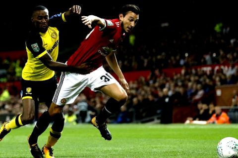 Burnley's Chris Wood, left, and Manchester United's Matteo Darmian chase after the ball during their English League Cup soccer match at Old Trafford in Manchester, England, Wednesday Sept. 20, 2017. (Martin Rickett/PA via AP)