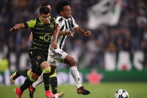 Juventus' forward from Colombia Juan Cuadrado (R) vies with Sporting's Argentinian forward Marcos Acuna during the UEFA Champions League Group D football match Juventus vs Sporting CP at the Juventus stadium on October 17, 2017 in Turin.  / AFP PHOTO / Marco BERTORELLO        (Photo credit should read MARCO BERTORELLO/AFP/Getty Images)