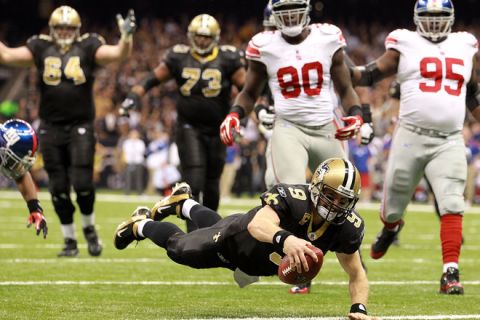 NEW ORLEANS, LA - NOVEMBER 28:  Drew Brees #9 of the New Orleans Saints dives into the endzone for a touchdown against the New York Giants at Mercedes-Benz Superdome on November 28, 2011 in New Orleans, Louisiana.  (Photo by Ronald Martinez/Getty Images)