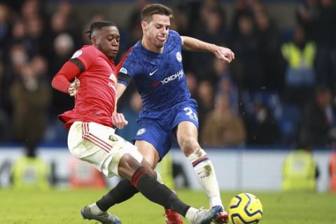 Manchester United's Aaron Wan-Bissaka, left, attempts a tackle on Chelsea's Cesar Azpilicueta during the English Premier League soccer match between Chelsea and Manchester United at Stamford Bridge in London, England, Monday, Feb. 17, 2020. (AP Photo/Ian Walton)