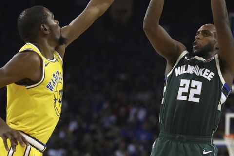 Milwaukee Bucks' Khris Middleton, right, shoots over Golden State Warriors' Kevin Durant during the second half of an NBA basketball game Thursday, Nov. 8, 2018, in Oakland, Calif. (AP Photo/Ben Margot)
