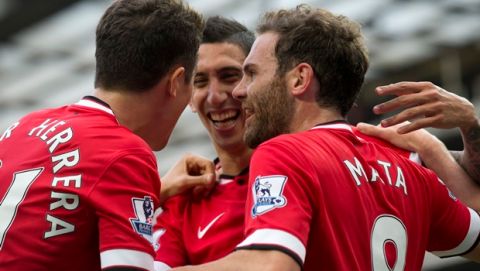 Manchester United's Juan Mata, right, celebrates with teammates Angel Di Maria, centre, and Abder Herrera after scoring against Queens Park Rangers during their English Premier League soccer match at Old Trafford Stadium, Manchester, England, Sunday Sept. 14, 2014. (AP Photo/Jon Super)