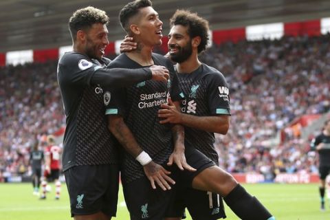 Liverpool's Roberto Firmino, centre, celebrates scoring his side's second goal of the game with teammates, during the English Premier League soccer match between Everton and Watford, at Goodison Park, in Liverpool, England,  Saturday, Aug. 17, 2019. (Ian Hodgson/PA via AP)