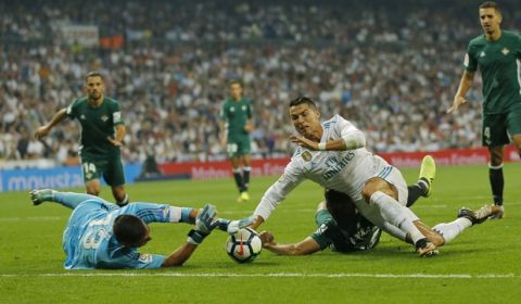 Real Madrid's Cristiano Ronaldo, right, falls down next to Betis' Antonio Adan during the Spanish La Liga soccer match between Real Madrid and Real Betis at the Santiago Bernabeu stadium in Madrid, Wednesday, Sept. 20, 2017. (AP Photo/Francisco Seco)
